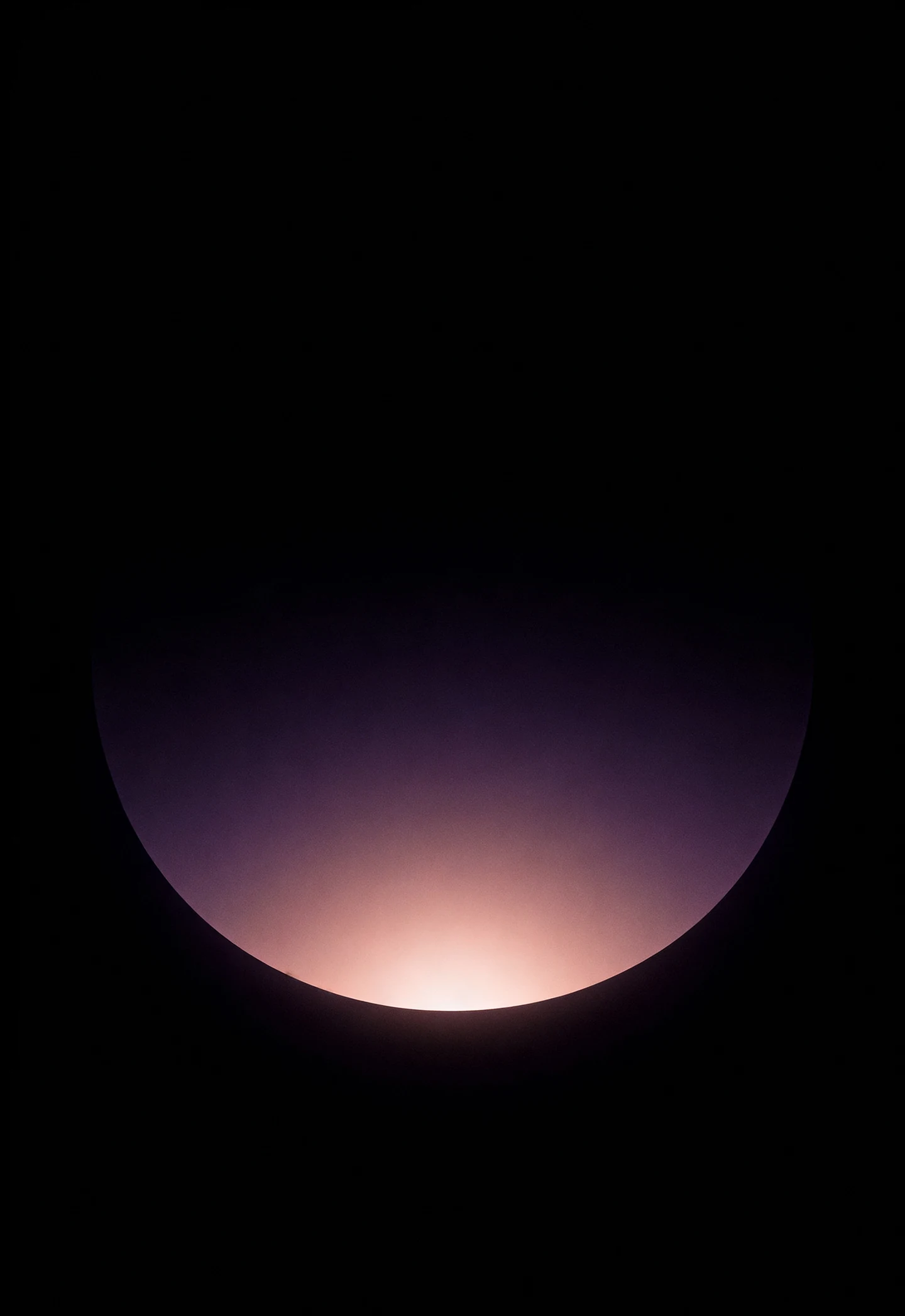 AMOLED & Dark wallpaper fitted to the iPhone Duo outer display — a soft mauve mist glowing low against deep black, held in plain dark space