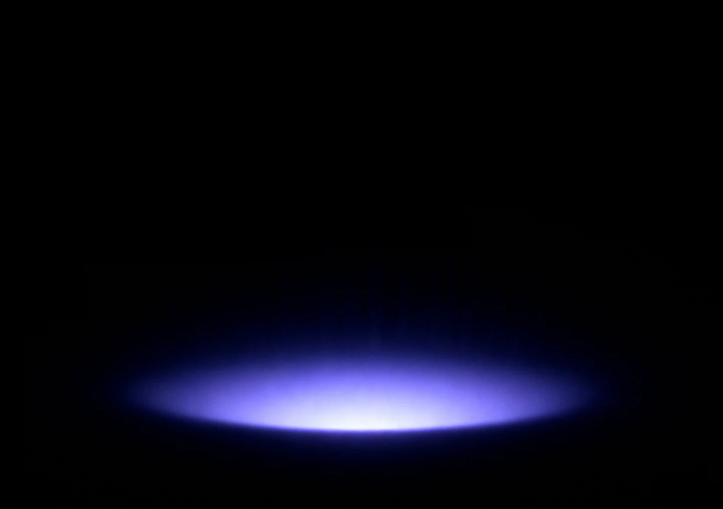 AMOLED & Dark wallpaper fitted to the iPhone Duo inner display — a single soft indigo elliptical halo glowing low on pure black